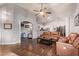 Spacious living room with wood floors, vaulted ceilings, and leather furniture at 3922 N 125Th Dr, Avondale, AZ 85392