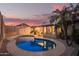 Serene backyard featuring a refreshing pool, palm trees, and a view of the home at 3922 N 125Th Dr, Avondale, AZ 85392
