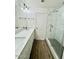 Bathroom featuring double sink vanity, marble tile shower, and wood-look floors at 42418 W Sunland Dr, Maricopa, AZ 85138