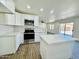 Stylish kitchen with stainless steel appliances, white cabinets, and a central island for ample counter space at 42418 W Sunland Dr, Maricopa, AZ 85138