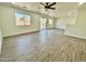 Bright living room featuring wood-style flooring and multiple windows for natural light at 42418 W Sunland Dr, Maricopa, AZ 85138