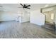 Spacious living room with wood-style flooring, open layout, and modern ceiling fan at 42418 W Sunland Dr, Maricopa, AZ 85138