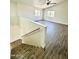 Bright living room featuring wood-look floors, two windows, and a ceiling fan at 42418 W Sunland Dr, Maricopa, AZ 85138