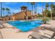 A large community pool featuring sun loungers and palm trees at 4901 S Calle Los Cerros Dr # 219, Tempe, AZ 85282
