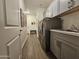 Well-organized laundry room featuring gray cabinets, modern washer and dryer units, and tiled floors at 5100 E Rancho Paloma Dr # 1044, Cave Creek, AZ 85331