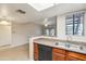 Open kitchen featuring wood cabinets, stainless steel sink, and a view of the living room at 5757 W Eugie Ave # 1080, Glendale, AZ 85304