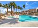 Community pool surrounded by lounge chairs and palm trees at 5757 W Eugie Ave # 1080, Glendale, AZ 85304