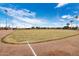Well-maintained baseball field with grassy infield and clear skies at 625 S Westwood -- # 121, Mesa, AZ 85210