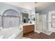 Bathroom featuring a separate tub, glass enclosed shower, and spacious vanity at 639 N 110Th Pl, Mesa, AZ 85207