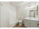Clean bathroom featuring a tiled shower-tub, toilet, vanity with mirror, and ample lighting for a refreshing experience at 6811 W Aire Libre Ave, Peoria, AZ 85382