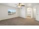 Spacious bedroom features a ceiling fan, neutral carpet, and an ensuite bathroom access at 6811 W Aire Libre Ave, Peoria, AZ 85382