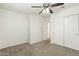 Bedroom featuring neutral carpet, a ceiling fan, closet and a door for convenient access to other rooms at 6811 W Aire Libre Ave, Peoria, AZ 85382