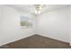 Simple bedroom with carpet, a ceiling fan, and natural light from the window, creating a serene space at 6811 W Aire Libre Ave, Peoria, AZ 85382