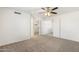 Spacious main bedroom with neutral carpet, ceiling fan, and closet access, blending comfort with practical design at 6811 W Aire Libre Ave, Peoria, AZ 85382