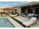 This backyard features a pool, spa, covered patio with lounge chairs, and outdoor seating for relaxation at 7158 E Posada Ave, Mesa, AZ 85212