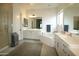 Bright bathroom featuring dual sinks, a soaking tub, walk-in shower, and tile flooring at 7158 E Posada Ave, Mesa, AZ 85212