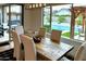 Bright dining room featuring a wooden table and views of the backyard pool at 7158 E Posada Ave, Mesa, AZ 85212