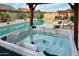 Relax in this backyard spa with a pool, outdoor kitchen, and pergola with seating at 7158 E Posada Ave, Mesa, AZ 85212