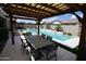 Covered patio with outdoor dining furniture overlooking a pool with water feature at 7158 E Posada Ave, Mesa, AZ 85212