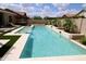 Sparkling pool with waterfall feature, artificial grass, and lounge chairs at 7158 E Posada Ave, Mesa, AZ 85212