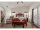 Bright bedroom with a wooden bed, bench, and French doors to the backyard at 7822 W Mcrae Way, Glendale, AZ 85308