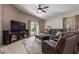 Cozy living room with plush leather seating and a ceiling fan at 7822 W Mcrae Way, Glendale, AZ 85308