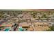 Wide aerial shot of neighborhood featuring a house with a private pool and patio, surrounded by green trees, and well-maintained lawns at 809 N 95Th St, Mesa, AZ 85207