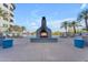 Resort-style pool area featuring a fireplace, lounge chairs, and lush palm trees at 945 E Playa Del Norte Dr # 4017, Tempe, AZ 85288