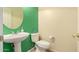 Half bath with a green accent wall, toilet, and a round mirror at 9625 W Prospector Dr, Queen Creek, AZ 85144