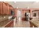 Gorgeous kitchen with stainless steel appliances, granite countertops, and wooden cabinets with seamless access to the home at 9625 W Prospector Dr, Queen Creek, AZ 85144