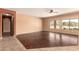 Open living room showcasing hardwood floors, light-colored walls, and a view of the backyard from the three large windows at 9625 W Prospector Dr, Queen Creek, AZ 85144