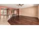Spacious living room featuring wood floors, ceiling fan, and neutral wall color with archways to other parts of the home at 9625 W Prospector Dr, Queen Creek, AZ 85144