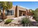 Desert landscaping surrounds a tiled patio with outdoor seating, ideal for relaxing and entertaining at 9653 E Sidewinder Trl, Scottsdale, AZ 85262