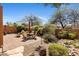 Inviting backyard with a stone-paved patio, landscaped greenery, and privacy walls at 9653 E Sidewinder Trl, Scottsdale, AZ 85262