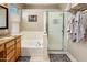The bright bathroom features a soaking tub, glass-enclosed shower, and tiled floors for easy maintenance at 9653 E Sidewinder Trl, Scottsdale, AZ 85262