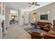 Spacious living room featuring a leather sofa, fireplace, and open access to the office at 9653 E Sidewinder Trl, Scottsdale, AZ 85262
