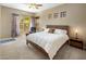 Relaxing main bedroom featuring a cozy chair, ceiling fan, and natural light from the large windows at 9653 E Sidewinder Trl, Scottsdale, AZ 85262