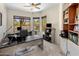 A spacious home office with three desks, built-in bookshelves, and plentiful natural light at 9653 E Sidewinder Trl, Scottsdale, AZ 85262