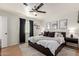 Spacious bedroom with a ceiling fan, black curtains, and modern decor at 1029 E Marco Polo Rd, Phoenix, AZ 85024