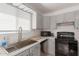 Bright kitchen featuring gray cabinetry, stainless steel sink, and black appliances at 1029 E Marco Polo Rd, Phoenix, AZ 85024