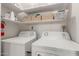 Bright laundry room with ample storage and two white washing machines at 1029 E Marco Polo Rd, Phoenix, AZ 85024