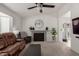 Comfortable living room featuring a decorative fireplace, ceiling fan, and carpet flooring at 1029 E Marco Polo Rd, Phoenix, AZ 85024