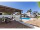 Backyard pool area featuring a pergola with outdoor seating and a well-maintained exterior at 1029 E Marco Polo Rd, Phoenix, AZ 85024