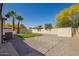 Spacious backyard with a putting green, patio area, desert landscaping, and white privacy fence at 1064 S 97Th St, Mesa, AZ 85208