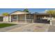 Tan home shows a covered front porch, low maintenance gravel yard, and an attached, covered carport at 1064 S 97Th St, Mesa, AZ 85208