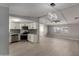 This open concept shows gray-toned flooring, white cabinets, stainless steel appliances, and a tile backsplash at 1064 S 97Th St, Mesa, AZ 85208