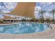 Resort-style pool with a sun shade and lounge chairs in a community at 1197 W Fir Tree Rd, Queen Creek, AZ 85140