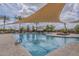 Large community pool under a sun shade featuring lush landscaping and lounge chairs at 1197 W Fir Tree Rd, Queen Creek, AZ 85140
