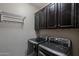 Well-equipped laundry room with modern washer, dryer, and overhead cabinets at 1197 W Fir Tree Rd, Queen Creek, AZ 85140