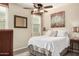 Cozy bedroom features a ceiling fan, plush bedding, and a bright window at 13051 W Black Hill Rd, Peoria, AZ 85383